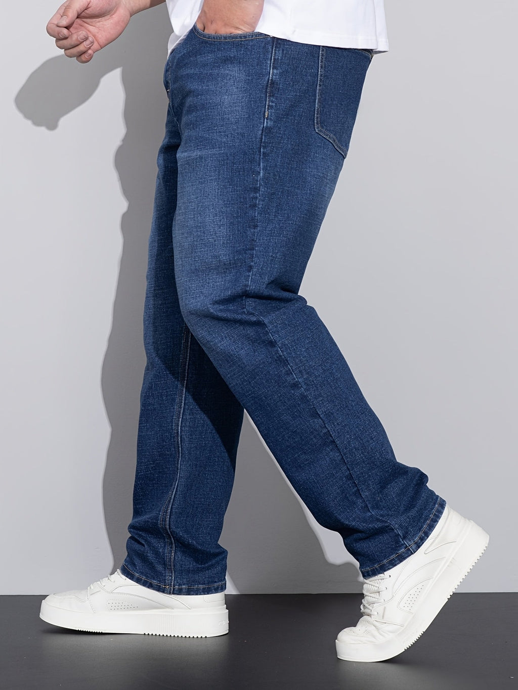 Blå jeans med lige ben, skrå sidevisning med hælkant og hvide sneakers