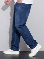 Blå jeans med lige ben, skrå sidevisning med hælkant og hvide sneakers