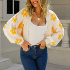 Kort cardigan med åben front i beige/hvid med gule indstrikkede blomster.