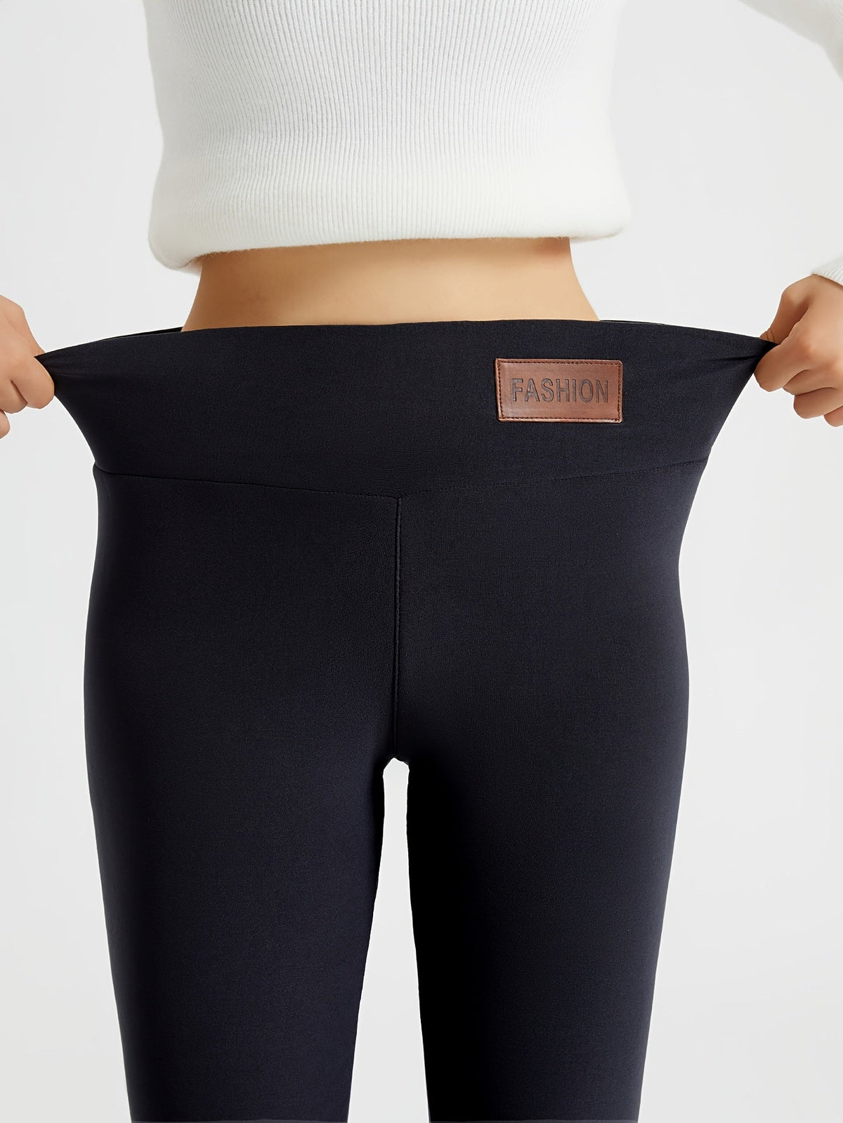 Højtaljede vinterleggings i sort med høj talje, diskret label og glat søm.