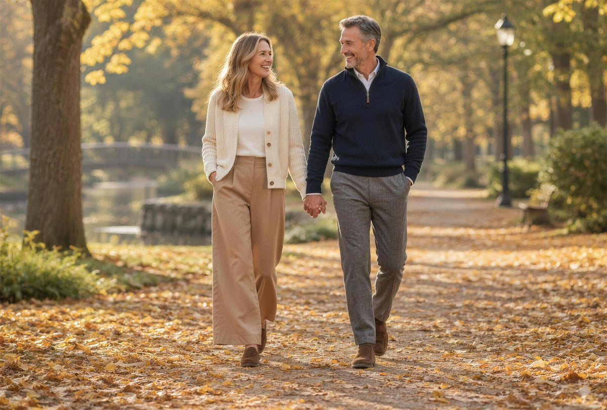 A couple in warm wool coats walking arm in arm on an autumn street